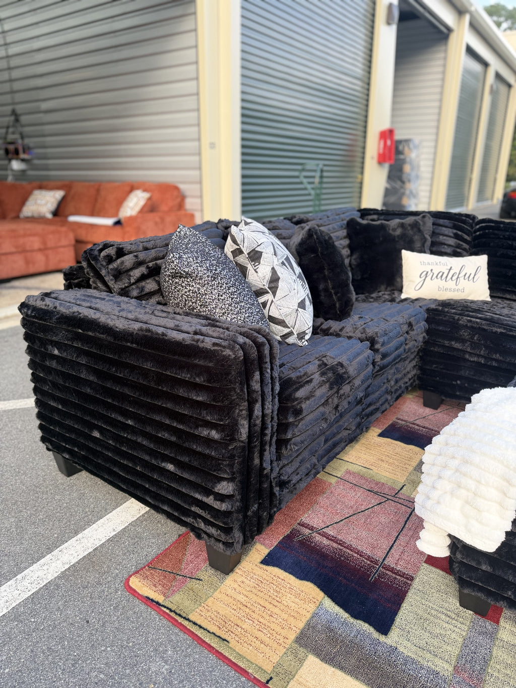 Black corduroy sectional side view with pillows